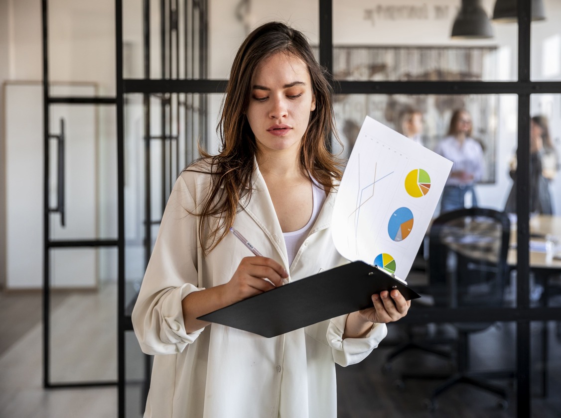 Female digital marketing specialist analyzing charts during a creative campaign presentation