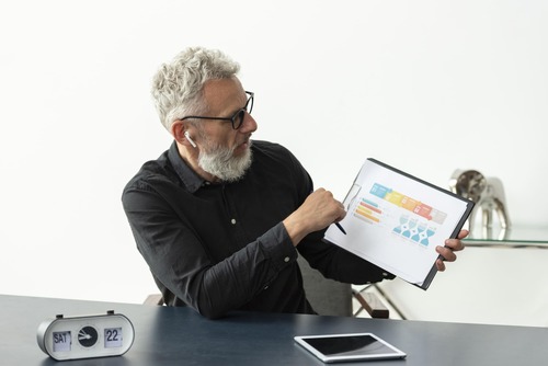 Senior strategist showcasing digital marketing performance metrics on a tablet