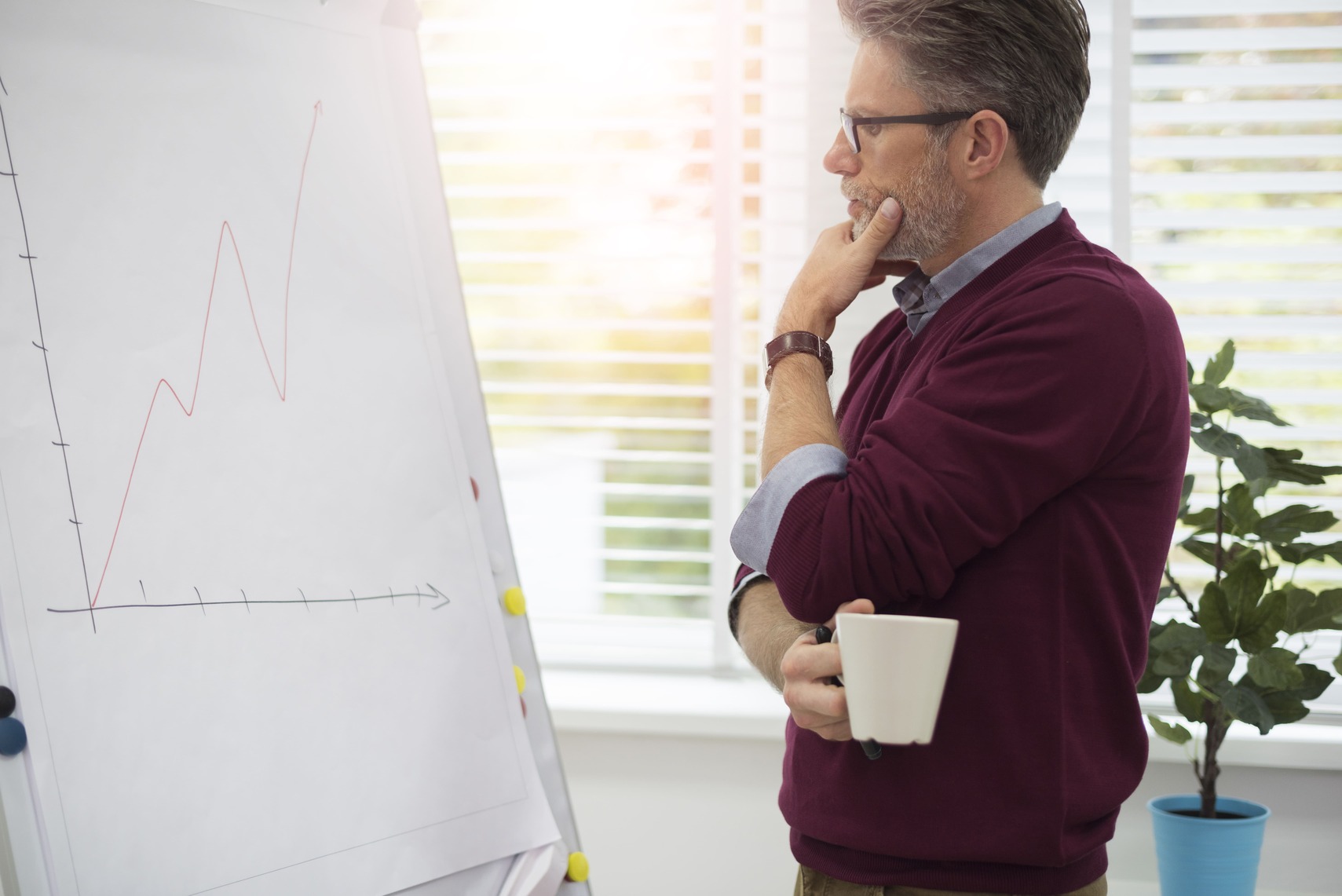 Creative director reviewing campaign analytics on a flipchart in a digital agency office